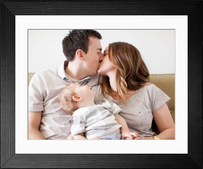 Framed Print : USA, Utah, Salt Lake City, Young couple kissing with baby boy (6-11 months) on their lap