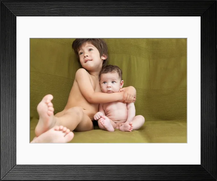 Framed Print : A young boy and his baby brother lying on the couch Framed Print : A young boy and his baby brother lying on the couch