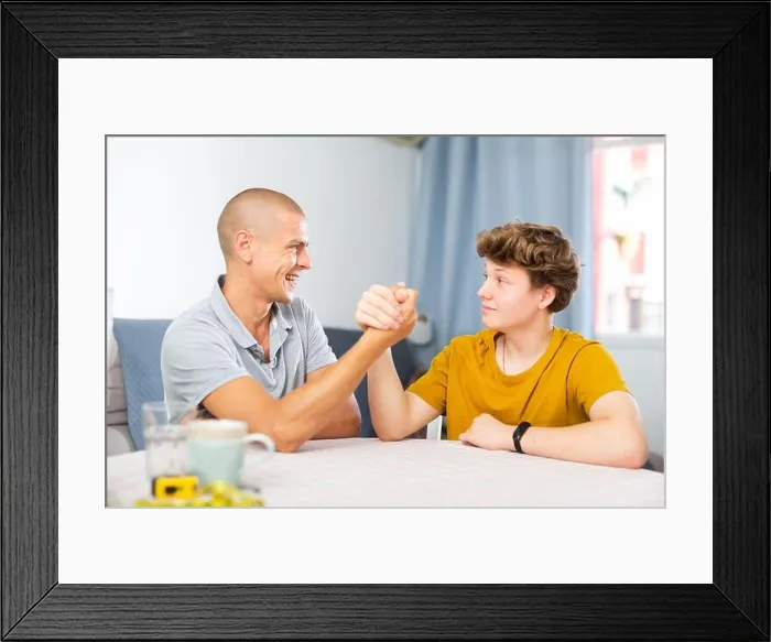 Framed Print : Son and his dad arm wrestling