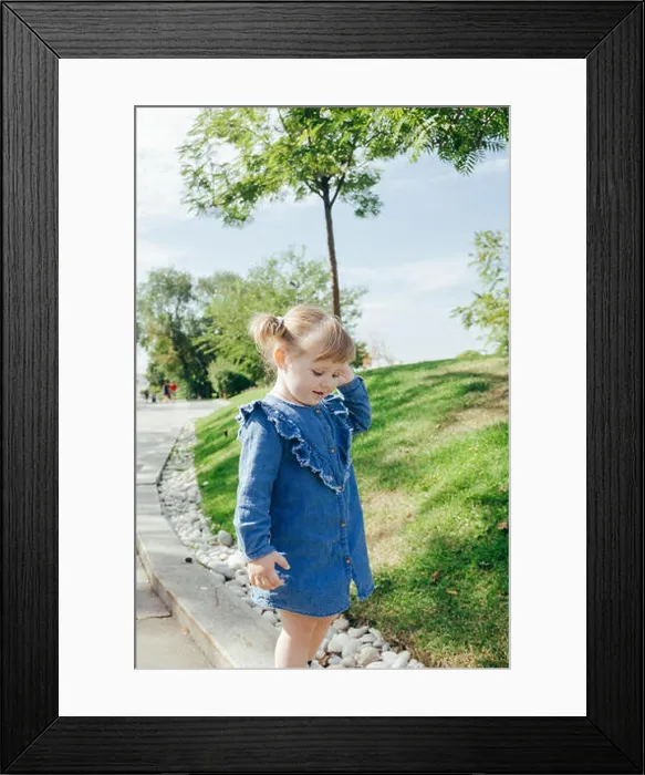 Framed Print : Little 3 years old girl in a blue jeans dress walking in a park on a warm sunny day Framed Print : Little 3 years old girl in a blue jeans dress walking in a park on a warm sunny day