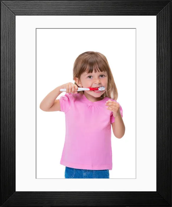 Framed Print : Portrait of cute little girl 3 year old in pink t-shirt brushing her teeth isolated on white background