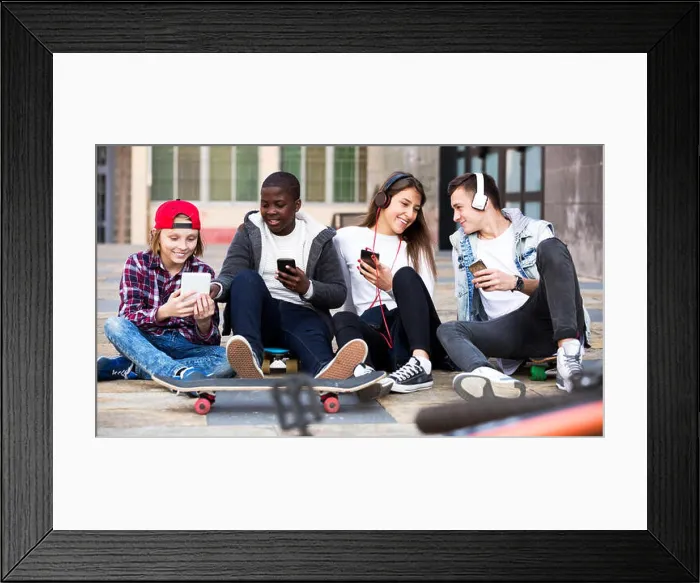 Framed Print : Happy teens playing on smarthphones and listening to music
