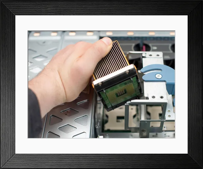 Framed Print : Computer technician installing CPU into motherboard