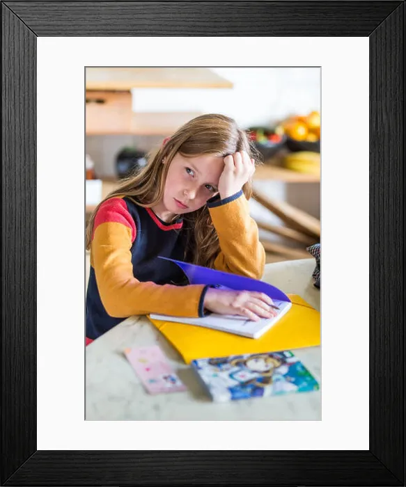 Framed Print : 9-year-old girl doing her homework Framed Print : 9-year-old girl doing her homework