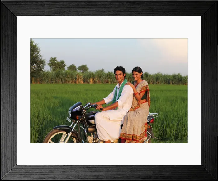 Framed Print : Indian rural couple riding on a motorcycle in the field Framed Print : Indian rural couple riding on a motorcycle in the field