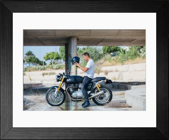 Framed Print : Side view of male biker sitting on motorcycle parked under bridge and putting on protective helmet Framed Print : Side view of male biker sitting on motorcycle parked under bridge and putting on protective helmet
