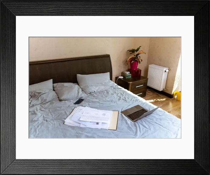 Framed Print : view of laptop with documents on bed. home work concept Framed Print : view of laptop with documents on bed. home work concept