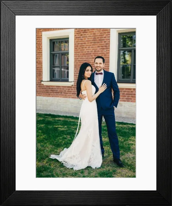 Framed Print : Vertical portrait of attractive bride and handsome bridegroom stand close to each other Framed Print : Vertical portrait of attractive bride and handsome bridegroom stand close to each other