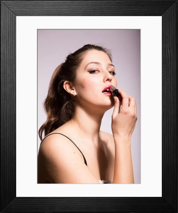 Framed Print : Young woman applying red lipstick Framed Print : Young woman applying red lipstick
