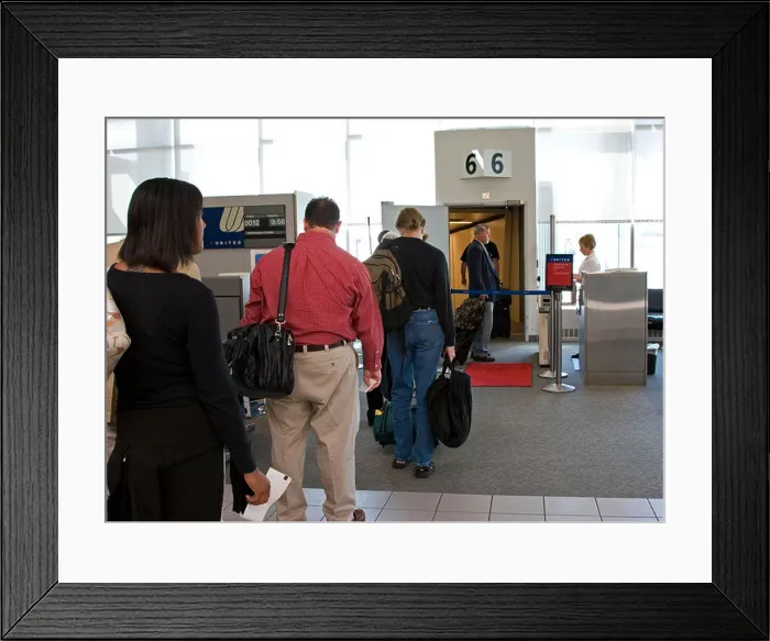 Framed Print : Passengers line up at airport gate to board plane Framed Print : Passengers line up at airport gate to board plane