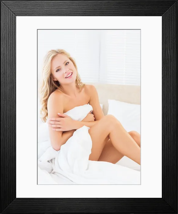 Framed Print : Naked smiling young woman covering herself with duvet Framed Print : Naked smiling young woman covering herself with duvet