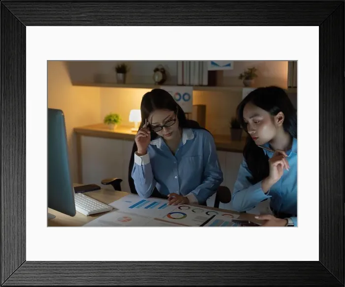Framed Print : Strategic Planning. Two women analyzing budget data and charts in a cozy office environment Framed Print : Strategic Planning. Two women analyzing budget data and charts in a cozy office environment