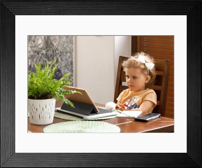 Framed Print : Baby girl 3 years old with curly hair is sitting at table Framed Print : Baby girl 3 years old with curly hair is sitting at table