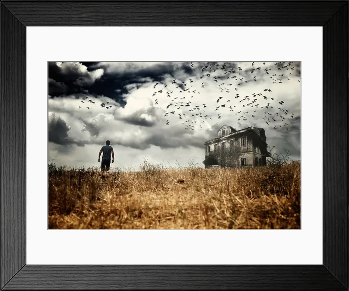 Framed Print : Man walking in a field towards a haunted house Framed Print : Man walking in a field towards a haunted house