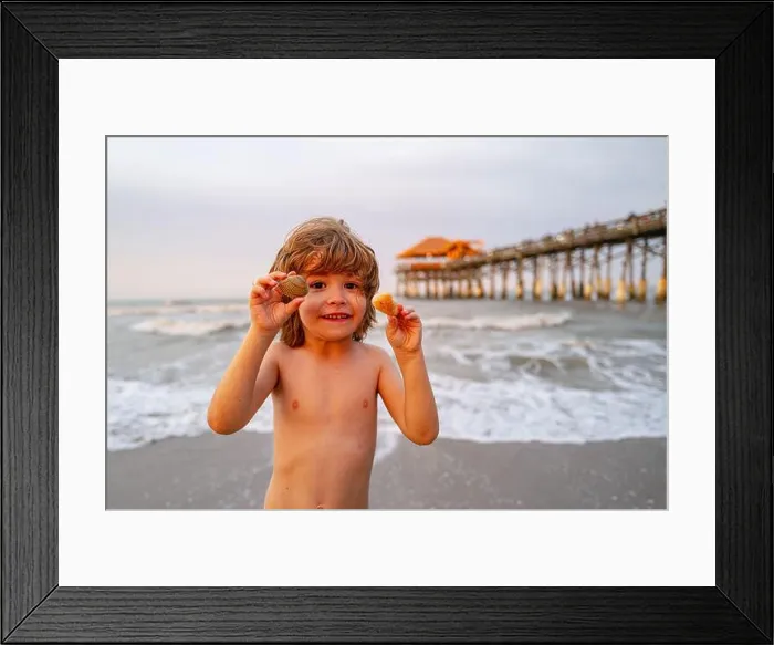 Framed Print : Cute, happy child holding shell at the beach Framed Print : Cute, happy child holding shell at the beach