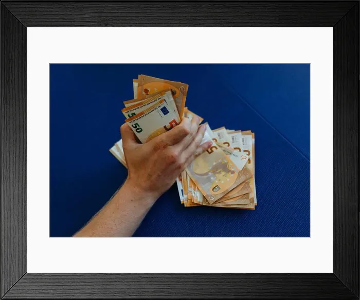 Framed Print : close-up view of man hand holding a pile of money Framed Print : close-up view of man hand holding a pile of money