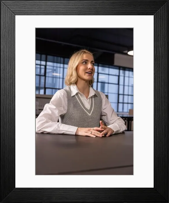 Framed Print : Female professional sitting at conference table in office space Framed Print : Female professional sitting at conference table in office space