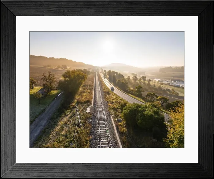 Framed Print : Landscape at sunrise with parallel railway tracks and country road Framed Print : Landscape at sunrise with parallel railway tracks and country road