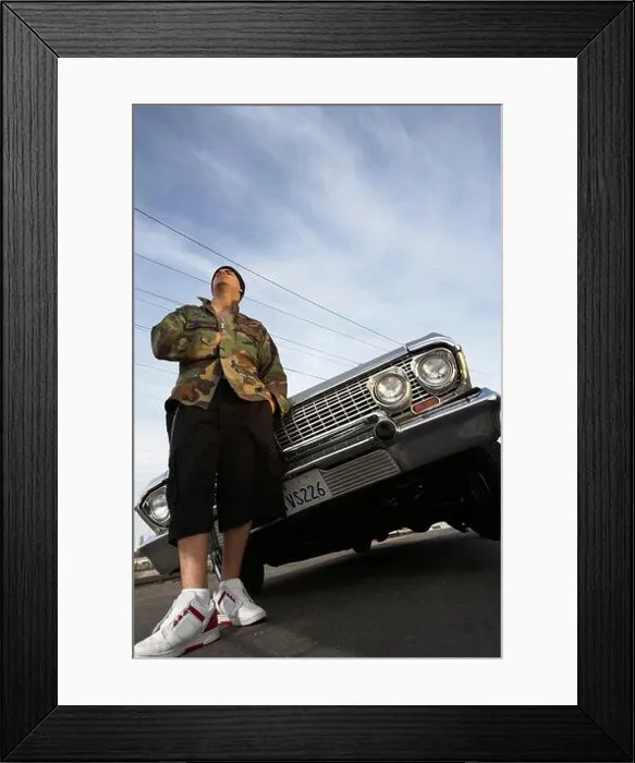 Framed Print : Man standing in front of car low angle view Framed Print : Man standing in front of car low angle view