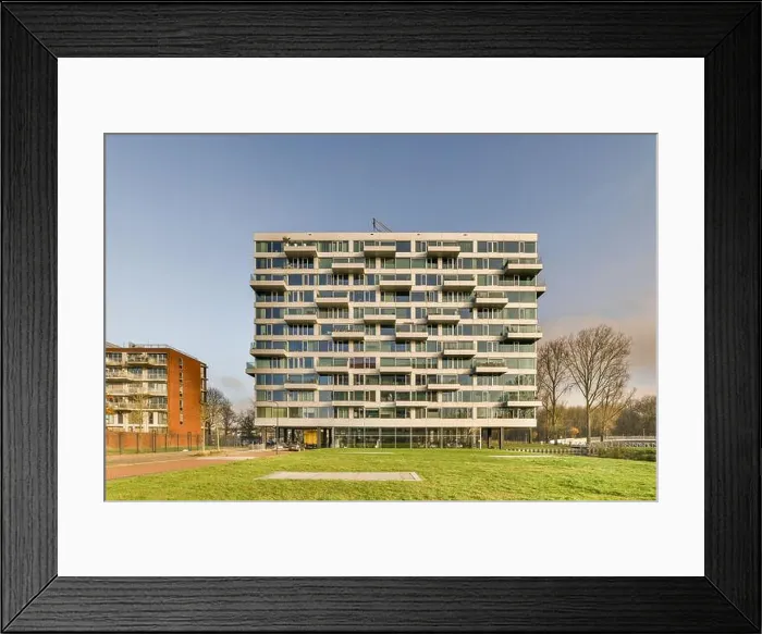 Framed Print : a modern building in the middle of a grassy area with trees and buildings on either side of the grass field Framed Print : a modern building in the middle of a grassy area with trees and buildings on either side of the grass field