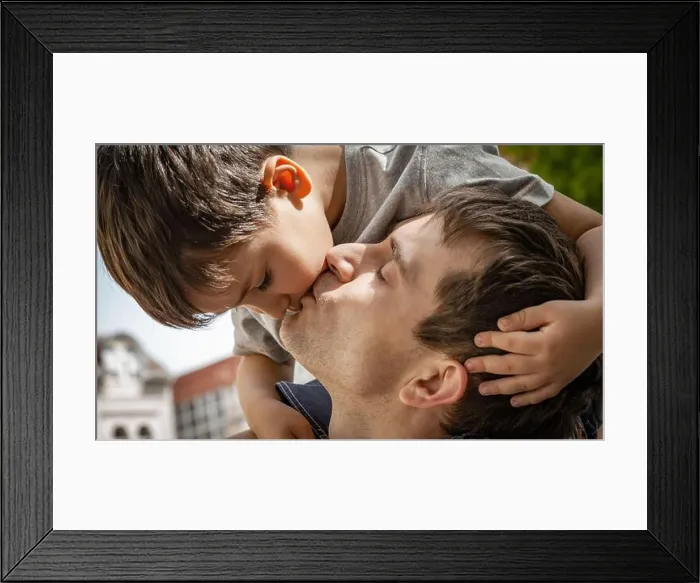 Framed Print : Family and happy lifestyle concept. Happy family portrait. Child playing with his father. Father kisses son Framed Print : Family and happy lifestyle concept. Happy family portrait. Child playing with his father. Father kisses son