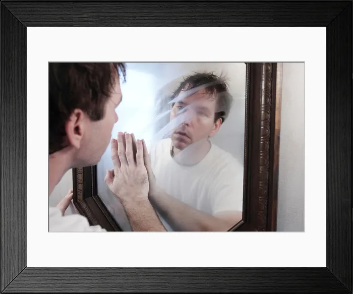 Framed Print : A man wiping a foggy mirror while looking at his reflection in the mirror in the morning