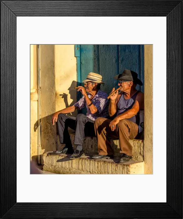 Framed Print : Two old Cubans smoke cigars and sit on a staircase in the warm light of the sunset Framed Print : Two old Cubans smoke cigars and sit on a staircase in the warm light of the sunset