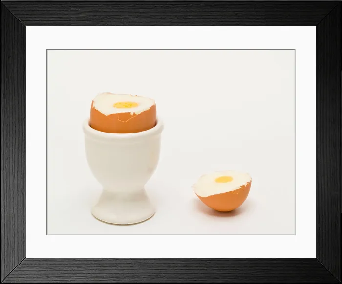 Framed Print : ein geköpftes Hühnerei steht im Eierbecher | one beheaded hen's egg in a eggcup Framed Print : ein geköpftes Hühnerei steht im Eierbecher | one beheaded hen's egg in a eggcup