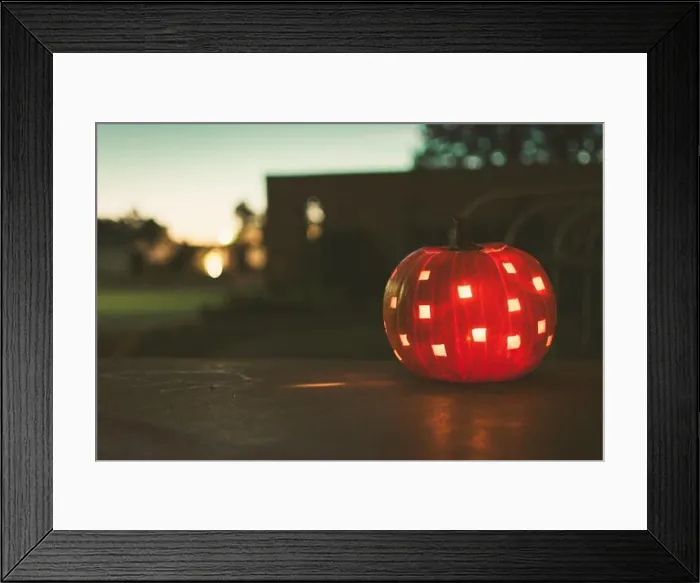 Framed Print : A lit jack o lantern sitting on a porch near dark on an autumn evening Framed Print : A lit jack o lantern sitting on a porch near dark on an autumn evening