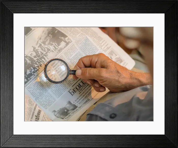 Framed Print : Old man reading newspapers with loupe, old repaired fixed magnifying glass Framed Print : Old man reading newspapers with loupe, old repaired fixed magnifying glass