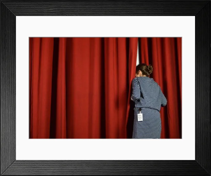 Framed Print : woman with a backstage pass looking behind the red curtains on a stage Framed Print : woman with a backstage pass looking behind the red curtains on a stage