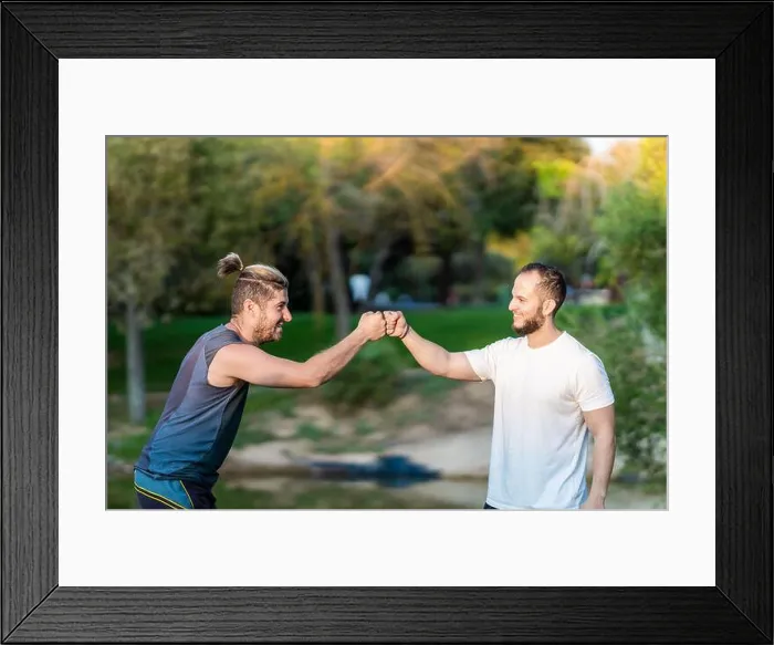 Framed Print : Two men clashing fists in a park Framed Print : Two men clashing fists in a park