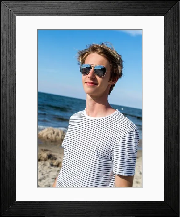 Framed Print : blond teenage boy in mirror glasses standing on the sandy beach Framed Print : blond teenage boy in mirror glasses standing on the sandy beach
