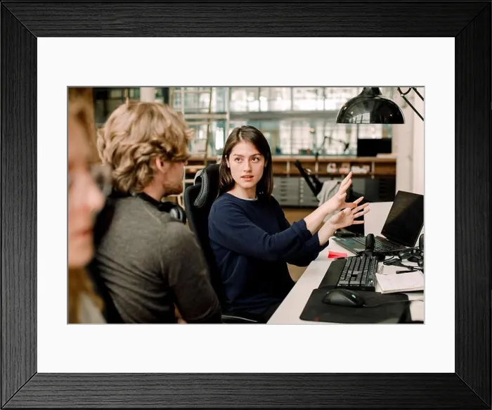 Framed Print : Entrepreneur explaining to colleague while sitting in office Framed Print : Entrepreneur explaining to colleague while sitting in office
