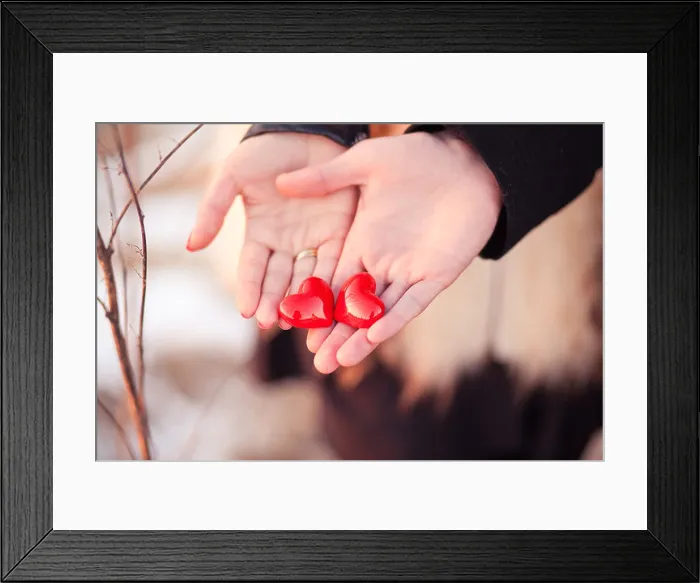Framed Print : Lovers couple are holding pair of hearts in their hands as a symbol of love Framed Print : Lovers couple are holding pair of hearts in their hands as a symbol of love