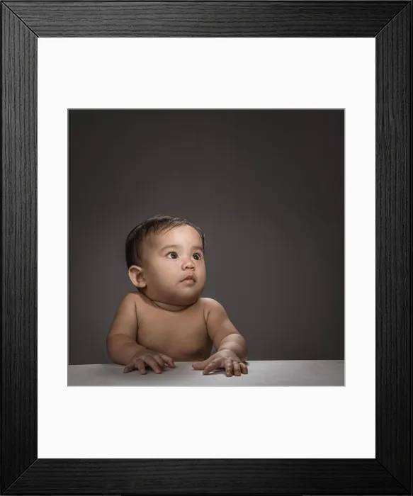 Framed Print : close up of baby face look up thinking over grey background Framed Print : close up of baby face look up thinking over grey background