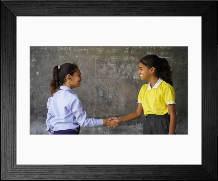 Framed Print : Happy Indian school girl child standing in front of black chalkboard background. Education Concept or Back to School