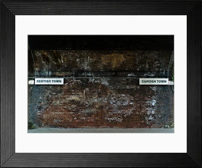Framed Print : Kentish Town and Camden direction signs under Victorian railway bridge that divides the two areas Framed Print : Kentish Town and Camden direction signs under Victorian railway bridge that divides the two areas