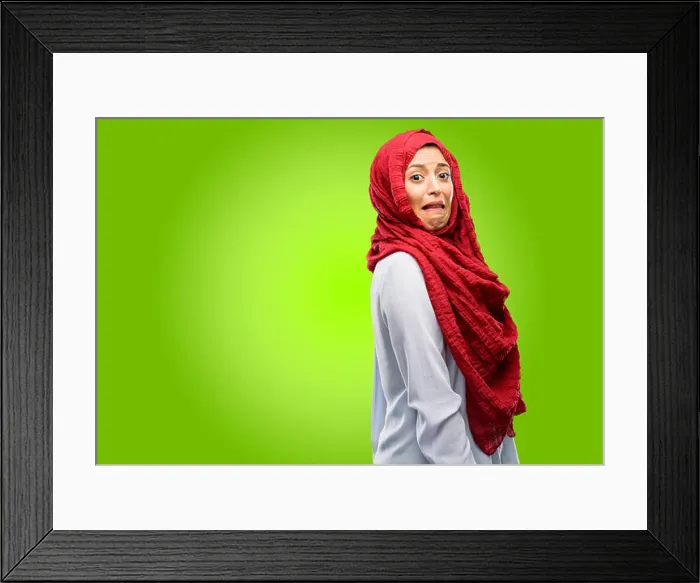 Framed Print : Young arab woman wearing hijab feeling disgusted with tongue out Framed Print : Young arab woman wearing hijab feeling disgusted with tongue out