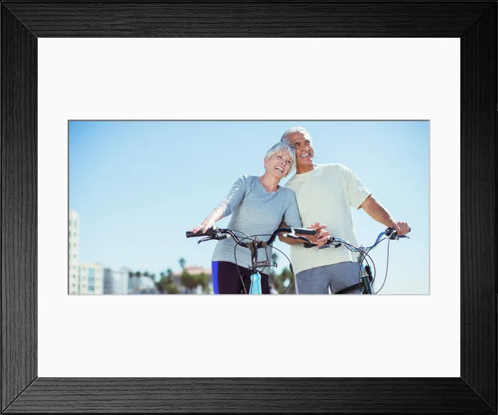 Framed Print : Senior couple with bicycles on beach Framed Print : Senior couple with bicycles on beach