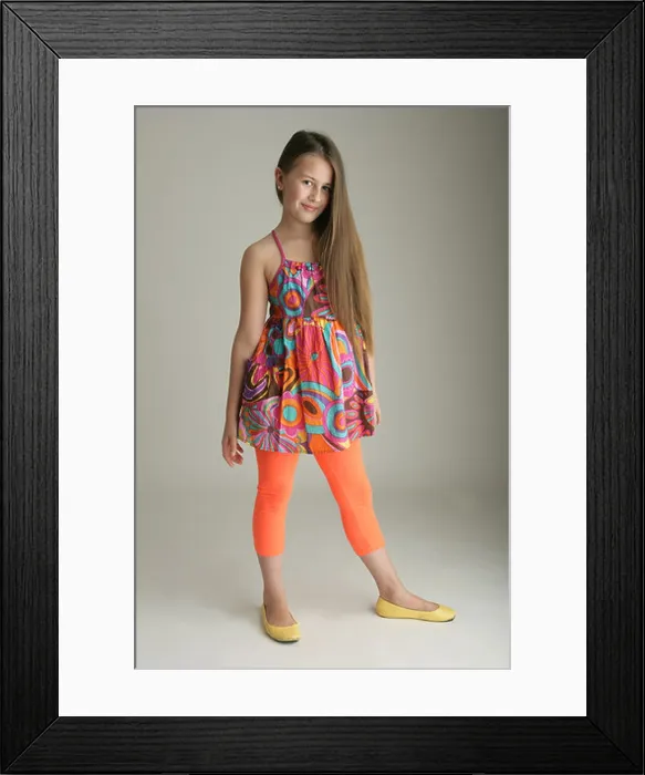 Framed Print : Portrait of a ten year old girl standing in a studio Framed Print : Portrait of a ten year old girl standing in a studio