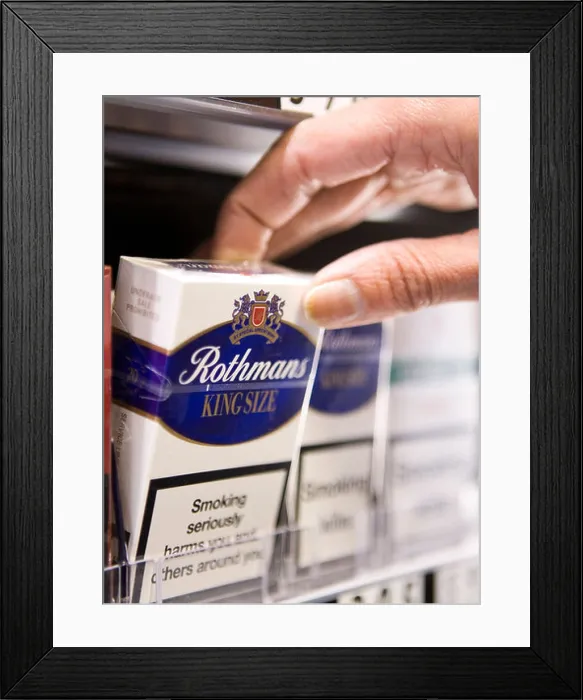 Framed Print : Packets of Rothmans cigarettes made by British American Tobacco sit on the shelf of a retail store Framed Print : Packets of Rothmans cigarettes made by British American Tobacco sit on the shelf of a retail store