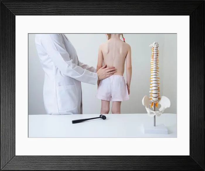 Framed Print : A pediatric neurologist doctor examines the back of a 5-year-old girl who has back pain Framed Print : A pediatric neurologist doctor examines the back of a 5-year-old girl who has back pain