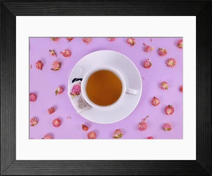 Framed Print : Cup of tea surrounded by dried globe amaranth flowers on violet background Framed Print : Cup of tea surrounded by dried globe amaranth flowers on violet background