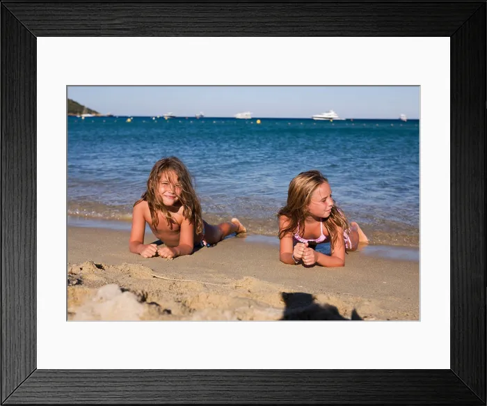 Framed Print : Young caucasian girls lying on the sand waiting for the waves. Plage de Pampelonne, Ramatuelle, ST TROPEZ, FRANCE Framed Print : Young caucasian girls lying on the sand waiting for the waves. Plage de Pampelonne, Ramatuelle, ST TROPEZ, FRANCE