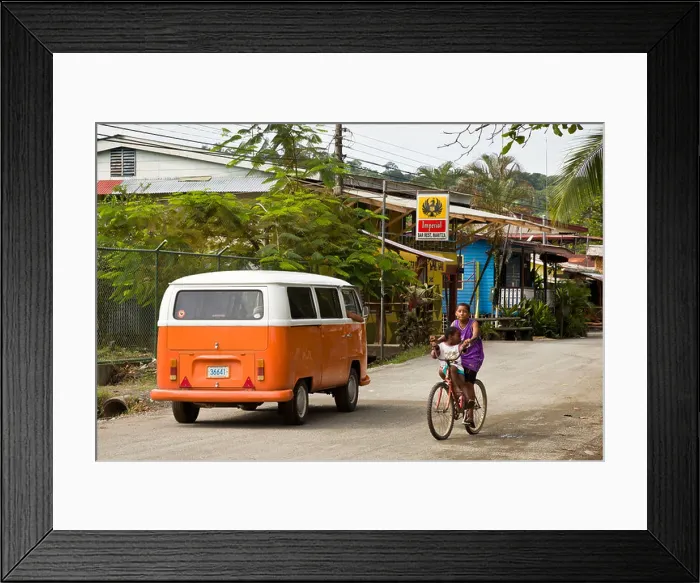 Framed Print : Two kids riding a bike on the street with an orange VW bus Puerto Viejo, Costa Rica Framed Print : Two kids riding a bike on the street with an orange VW bus Puerto Viejo, Costa Rica