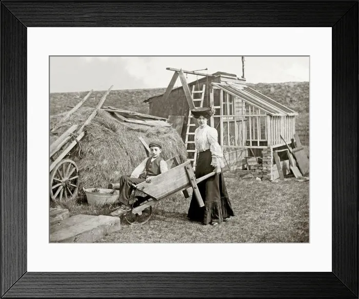 Framed Print : A woman pushing a man in a wheelbarrow Framed Print : A woman pushing a man in a wheelbarrow