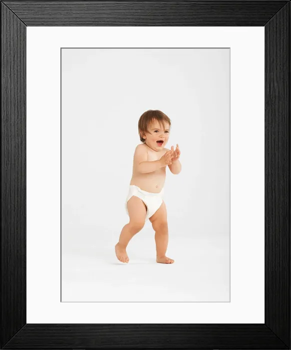 Framed Print : Excited toddler taking first steps in white studio Framed Print : Excited toddler taking first steps in white studio