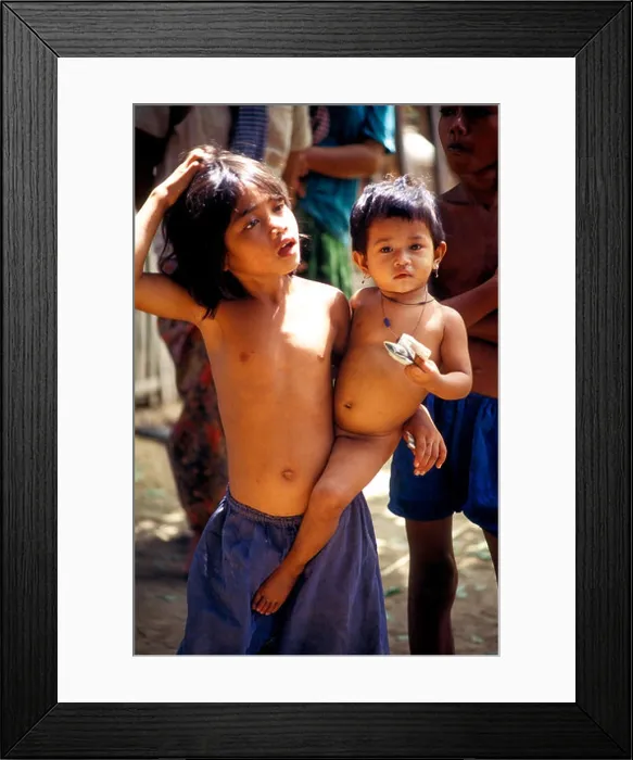 Framed Print : Young Cambodian girl carrying a toddler Framed Print : Young Cambodian girl carrying a toddler