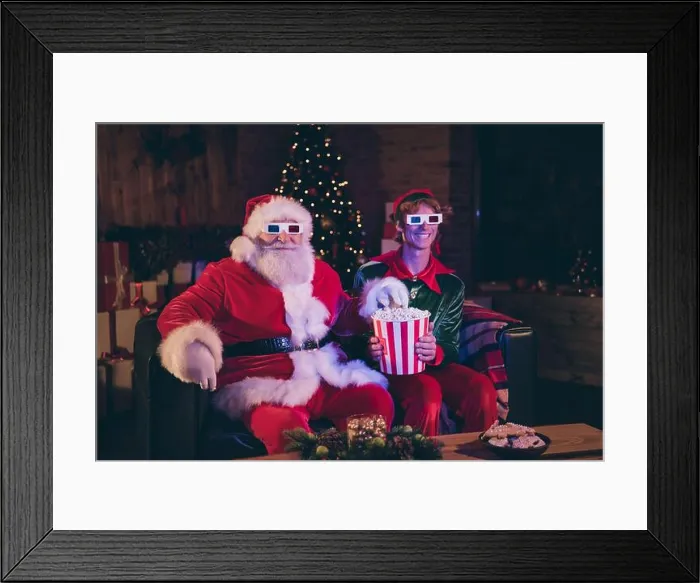 Framed Print : Photo portrait of santa claus and elf eating popcorn watching movie on sofa in 3d glasses Framed Print : Photo portrait of santa claus and elf eating popcorn watching movie on sofa in 3d glasses